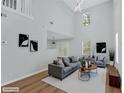 Modern living room with vaulted ceilings, hardwood flooring, and ample natural light with tastefully neutral staging at 3417 Sable Chase Ln, Atlanta, GA 30349