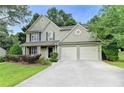 Charming two-story home featuring a well-maintained lawn, a two-car garage, and manicured landscaping at 5229 Pine Branch Ct, Sugar Hill, GA 30518