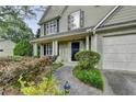 Inviting front entrance with a walkway framed by lush landscaping, leading to a charming front door and two-car garage at 5229 Pine Branch Ct, Sugar Hill, GA 30518