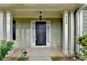 Welcoming front porch with classic columns, a stylish black door, and clear house number display at 5229 Pine Branch Ct, Sugar Hill, GA 30518