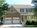 Charming two-story home featuring a stone facade, two-car garage, and well-maintained front lawn at 4750 Crinklepoint Ct, Douglasville, GA 30134