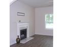 Cozy living room featuring a classic fireplace with marble accents and modern gray flooring at 4750 Crinklepoint Ct, Douglasville, GA 30134