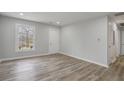 Bright living room with modern flooring, fresh paint, and natural light from the window overlooking the landscape at 6565 Bussell Way, Riverdale, GA 30274