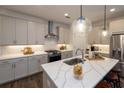 Modern kitchen with a waterfall island, stainless steel appliances, and elegant pendant lighting at 1005 Crown Oak St # 44, Johns Creek, GA 30022
