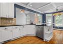 Modern kitchen featuring white cabinets, dark countertops, stainless steel appliances, and hardwood floors at 2525 Millwater Xing, Dacula, GA 30019