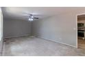 Open living room featuring grey walls, a ceiling fan, and an adjacent kitchen view at 6293 Silver Creek Ln, Austell, GA 30168
