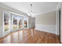 Bright dining room with hardwood floors, decorative molding, and a large bay window at 1192 Melton Sw Dr, Lilburn, GA 30047