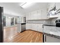 Modern kitchen featuring white cabinets, stainless steel appliances, and hardwood flooring at 1192 Melton Sw Dr, Lilburn, GA 30047