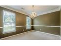 A spacious dining room features a chandelier, neutral walls, and a large window at 2563 Creek Ter, Snellville, GA 30078