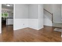 Elegant hallway with hardwood floors, staircase and white trim, leading to the kitchen at 64 Harbour Lake Dr, Fayetteville, GA 30215