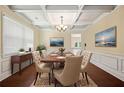Dining room with decorative coffered ceiling, wainscoting, wood floors, and elegant furniture at 4540 Fourth Rail Ln, Cumming, GA 30040