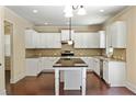 Bright kitchen with white cabinets, granite countertops, stainless steel appliances, and an island at 4540 Fourth Rail Ln, Cumming, GA 30040