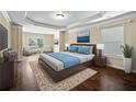 Main bedroom featuring a tray ceiling, large windows, and a sitting area with comfortable armchairs at 4540 Fourth Rail Ln, Cumming, GA 30040