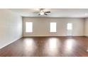 Bright and spacious living room featuring hardwood floors, large windows, and ample natural light at 513 Moline Way, Locust Grove, GA 30248