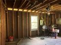 Interior room showing exposed studs, ceiling fan, window, and debris at 838 Old Allatoona Se Rd, Cartersville, GA 30121