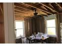Interior room showing exposed studs, windows, ceiling fan, and debris at 838 Old Allatoona Se Rd, Cartersville, GA 30121