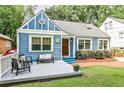Blue home featuring a charming covered porch, complemented by a lush, green lawn at 1136 Moreland Se Pl, Atlanta, GA 30316