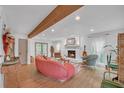 Cozy living room featuring a decorative fireplace, wood beam and an abundance of natural light at 201 Tweed Ct, Sugar Hill, GA 30518