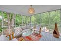 Relaxing screened porch offering comfortable seating and views of the private backyard at 201 Tweed Ct, Sugar Hill, GA 30518