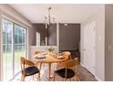 Cozy dining area features natural light, stylish chandelier, and seating for four at 9542 Canvasback Ct, Jonesboro, GA 30238