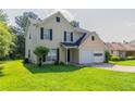 Traditional two-story home with a cozy front porch, two-car garage, and lush green lawn at 9542 Canvasback Ct, Jonesboro, GA 30238