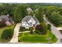 Aerial view of a beautiful two-story home with a lush green lawn and mature trees at 1023 Spruce Creek Ln, Lawrenceville, GA 30045