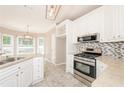 Bright kitchen with white cabinets, stainless steel appliances, granite countertops, and a stylish backsplash at 1305 Kelly Nelson Dr, Lawrenceville, GA 30043