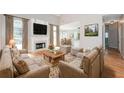 Cozy living room featuring a fireplace, hardwood floors, and ample seating with natural light at 1305 Kelly Nelson Dr, Lawrenceville, GA 30043