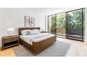 Modern bedroom featuring a wood bed frame, neutral decor, and sliding glass doors to a balcony at 2575 Peachtree Ne Rd # 6G, Atlanta, GA 30305