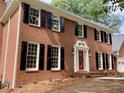 Up-close view of the red brick exterior featuring a red front door and black shutters at 3243 Northbrook Dr, Atlanta, GA 30341