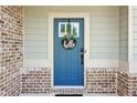 Close-up of a front door with decorative wreath, complemented by brick and siding exterior accents at 4172 Cedar Commons Way, Conley, GA 30288