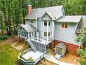 Back exterior featuring decks, screened in porch, and patio providing an outdoor living space with privacy at 120 Majesty Ln, Fayetteville, GA 30215