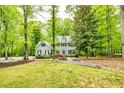 Traditional two-story home with black shutters, mature trees, manicured lawn, and meticulous landscaping at 120 Majesty Ln, Fayetteville, GA 30215