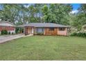 Beautiful single-story home with a lush green lawn, brick and wood accents, and a welcoming pergola entrance at 2468 Dresden Ne Dr, Atlanta, GA 30341