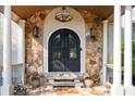 An inviting front entrance featuring a stone archway, a wrought iron double door, and elegant sconce lighting at 2917 Ashebrooke Ne Dr, Marietta, GA 30068