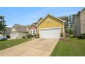 Home exterior view, with a two-car garage, manicured lawn and concrete driveway at 7761 Parkside Dr, Lithia Springs, GA 30122