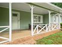Close-up of the front porch with seating and a decorative railing and front door at 2056 Merle Se Dr, Conyers, GA 30013