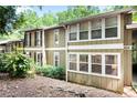 Exterior view of a two-story home with brown siding and white trim surrounded by mature trees and landscaping at 5145 Roswell Road # 3, Atlanta, GA 30342
