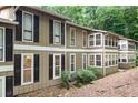 Exterior view of a two-story home with brown siding and black shutters surrounded by mature trees and landscaping at 5145 Roswell Road # 3, Atlanta, GA 30342