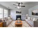 Cozy living room with plush sofas, a fireplace, decorative rug, and plenty of natural light at 7384 Birch Hollow Pl, Douglasville, GA 30134