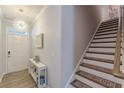 Inviting entryway with stylish light fixture, staircase with runner, and charming decor at 739 Woodstock Grove Dr, Woodstock, GA 30188