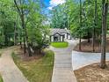 Charming home featuring a well-manicured lawn, a circular driveway, and lush greenery at 1126 Wedgefield Sw Dr, Marietta, GA 30064