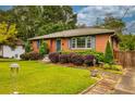 Front yard with shrubbery and grass alongside a brick home with inviting entry at 2191 Fairfield Se St, Smyrna, GA 30080