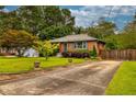 Brick home with driveway featuring landscaped yard and mature trees at 2191 Fairfield Se St, Smyrna, GA 30080