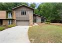 This home has a stone accent wall, a front-facing garage, and a well-manicured front yard at 225 Lakeview W Rdg, Roswell, GA 30076