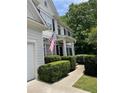 Charming two-story home featuring an American flag, manicured bushes, and traditional architectural details at 107 Sedgefield Overlook, Dallas, GA 30157