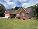 This brick home boasts manicured landscaping, a two-car garage, and lovely curb appeal at 1245 Mulberry Mill Ln, Lawrenceville, GA 30043