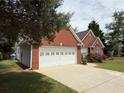View of this lovely brick home showing the two-car garage and well-maintained lawn at 1245 Mulberry Mill Ln, Lawrenceville, GA 30043
