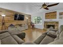 Cozy living room features a stone fireplace, wood accent wall, and comfortable seating at 1387 Sw Haynes Meadow Trl, Grayson, GA 30017