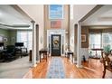 Bright and inviting foyer with hardwood floors, high ceilings, columns, and a decorative front door with sidelights at 424 Lake Point Trce, Canton, GA 30114